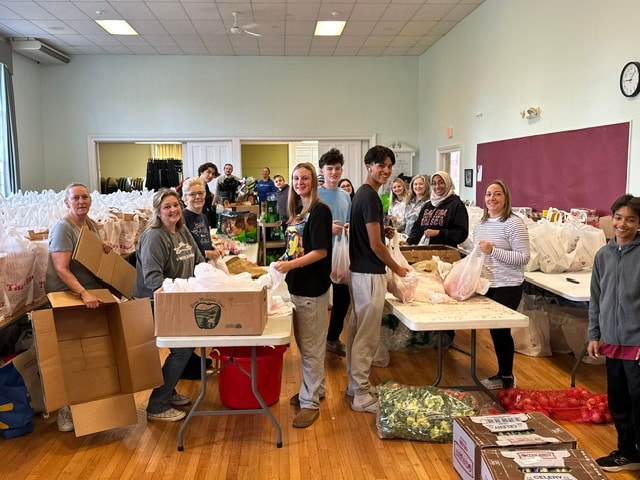 Volunteers packing food bags inside Fellowship Hall