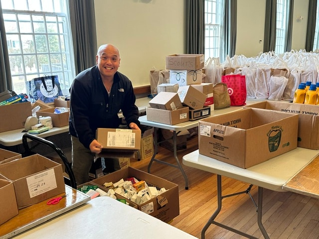 Volunteers handing food bags to families at Skeet's Pantry